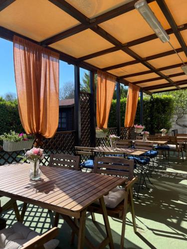 eine Terrasse mit Holztischen und -stühlen mit orangefarbenen Sonnenschirmen in der Unterkunft Smit House in Torre dell'Orso