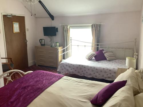 a bedroom with two beds and a window at The Bell Inn in Cheltenham