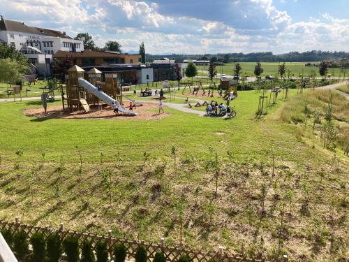 a park with a slide and people in a field at Landhaus ELisabeth Schwarzenberger in Obereching