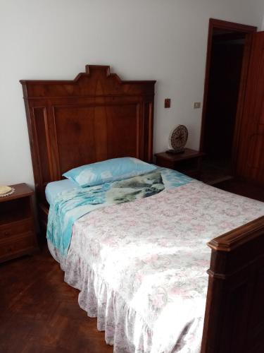 a bedroom with a large bed with a wooden headboard at Casa Romme in Tornolo