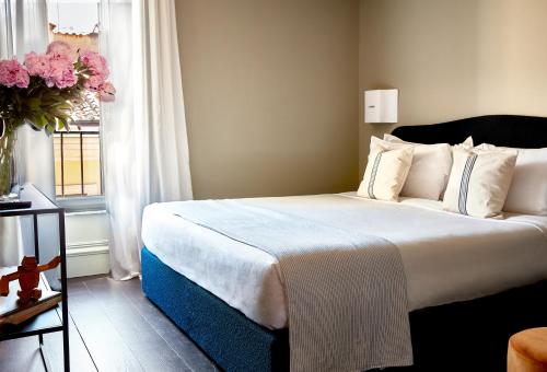 a bedroom with a white bedspread and white pillows at HOTEL VITE - By Naman Hotellerie in Rome