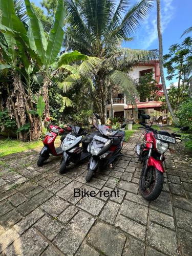 a group of motorcycles parked in front of a house at Tanzanite place in Tangalle
