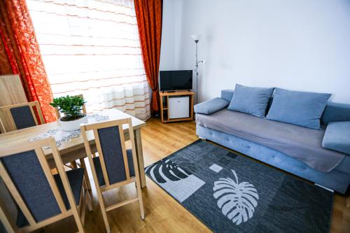 a living room with a blue couch and a table at Villa Nadmorska Łeba Centrum in Łeba