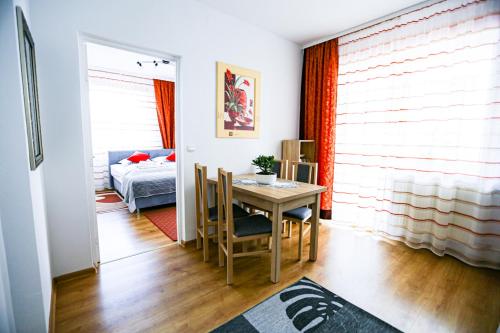 a room with a table and a bed and a bedroom at Villa Nadmorska Łeba Centrum in Łeba