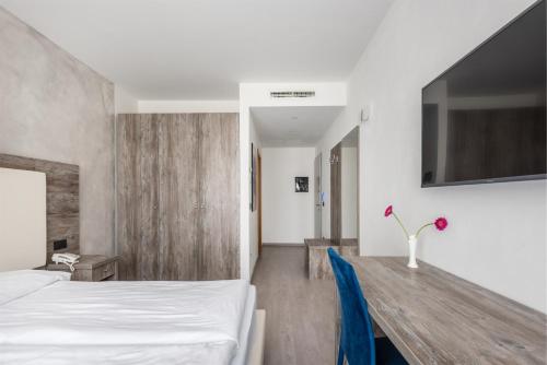 a hotel room with a bed and a wooden table at Hotel De Nac in Nago-Torbole