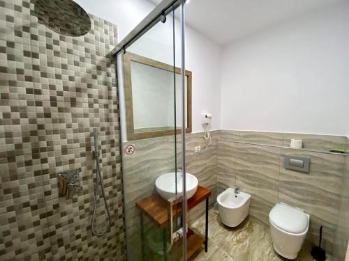 a bathroom with a shower and a sink and a toilet at Hotel Globo in Durrës