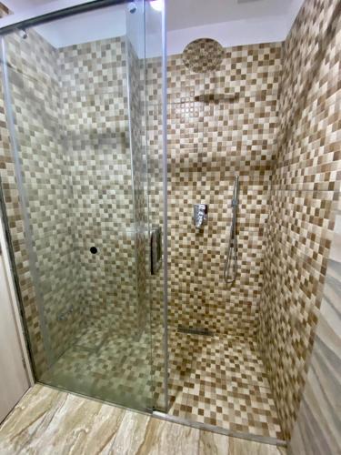 a bathroom with a shower with a glass door at Hotel Globo in Durrës
