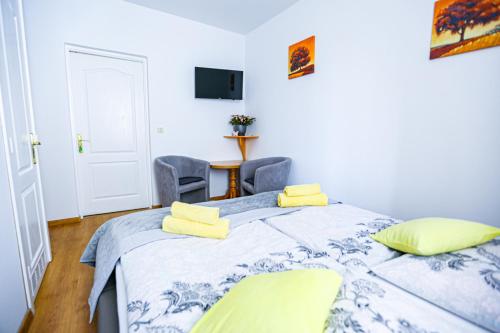 a bedroom with a bed with yellow towels on it at Villa Nadmorska Łeba Centrum in Łeba