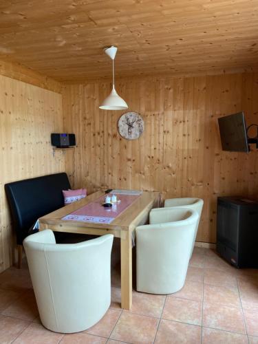 a dining room with a wooden table and chairs at Feriendorf Tauerngast in Hohentauern