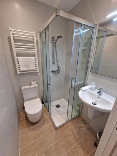 ein Bad mit einer Dusche, einem WC und einem Waschbecken in der Unterkunft Beach Break Guesthouse in San Sebastián