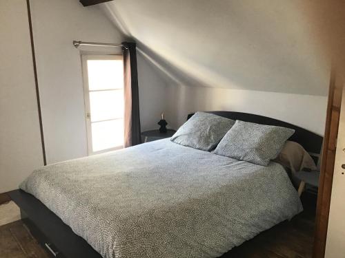 a bedroom with a large bed and a window at Maison De ville Bayeux in Bayeux