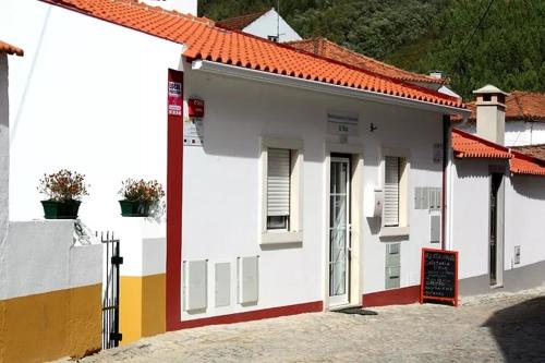 un edificio blanco con un cartel delante en Art`Rio - Casa no Rio em Dornes, en Dornes