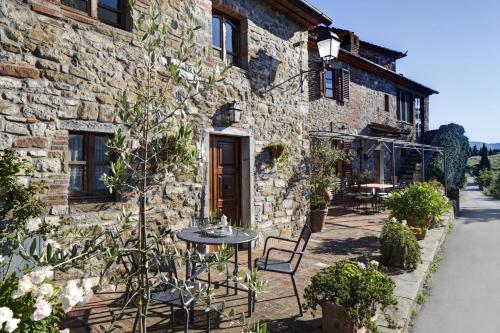 ein Steingebäude mit einem Tisch davor in der Unterkunft B&B Antiche Rime in Gaiole in Chianti