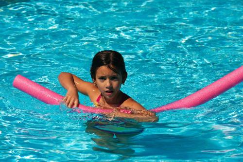 a young girl in a pool with two pink inflatables at Blue Horizon in Ialyssos