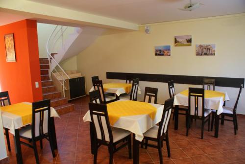 a restaurant with yellow tables and chairs and stairs at Casa Ardeleneasca in Timişoara