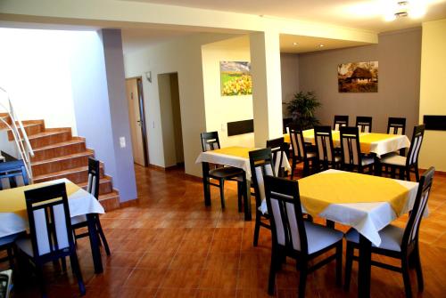 a restaurant with yellow tables and chairs and stairs at Casa Ardeleneasca in Timişoara