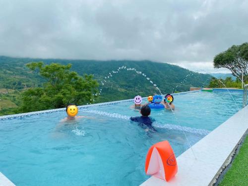 eine Gruppe von Menschen, die in einem Schwimmbad spielen in der Unterkunft Captain’s Villa and Campsite in Cebu City