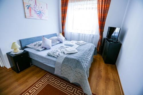 a bedroom with a bed and a window and a television at Villa Nadmorska Łeba Centrum in Łeba