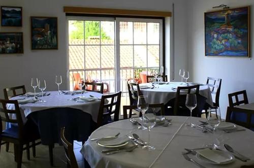 una sala da pranzo con tavoli e sedie con bicchieri da vino di Art`Rio - Casa no Rio em Dornes a Dornes