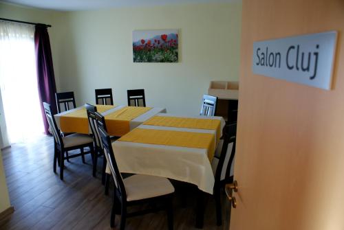 a dining room with a table and chairs and a sign at Casa Ardeleneasca in Timişoara