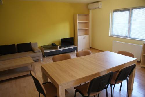 a living room with a wooden table and chairs at Casa Ardeleneasca in Timişoara