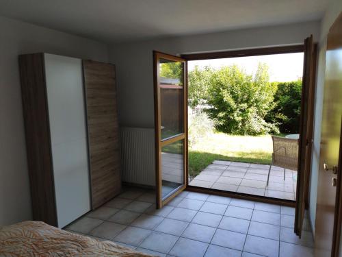 a bedroom with a door open to a patio at Ferienwohnung am Trillenbühl in Salem