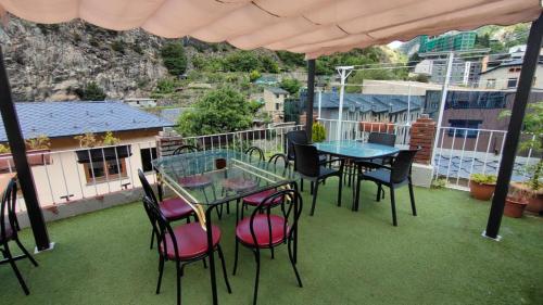 a patio with tables and chairs on a balcony at Alberg Els Andes in Andorra la Vella