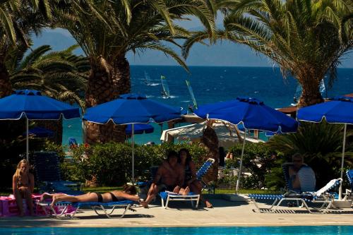a group of people sitting on lawn chairs by a pool at Blue Horizon in Ialyssos