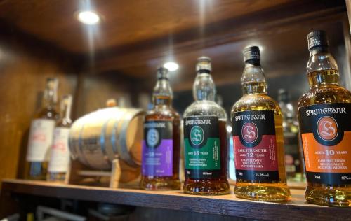 a row of bottles of alcohol sitting on a shelf at The Buckley Arms in Dinas Mawddwy