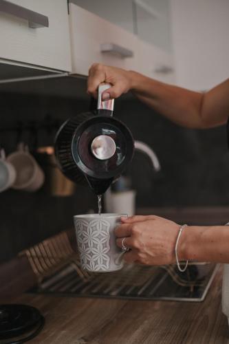 a person is pouring coffee into a cup at Gallery Apartment 2 in Martin
