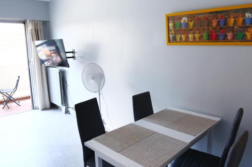 une salle à manger avec une table et des chaises et un tableau dans l'établissement Grand studio 4 couchages proche mer, à Antibes
