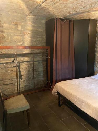 a bedroom with a bed and a chair in a room at Villa Gioia in Acqui Terme
