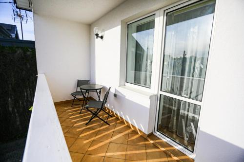 a balcony with a table and chairs and a window at Villa Nadmorska Łeba Centrum in Łeba