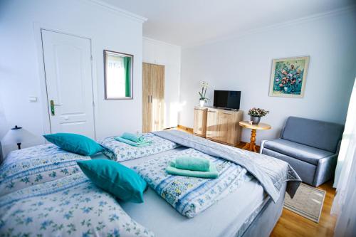 a bedroom with two beds with blue pillows and a chair at Villa Nadmorska Łeba Centrum in Łeba