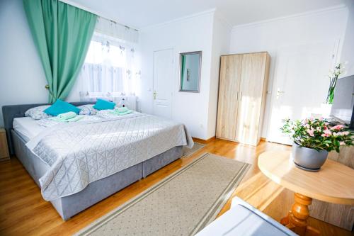 a bedroom with a large bed and a table at Villa Nadmorska Łeba Centrum in Łeba