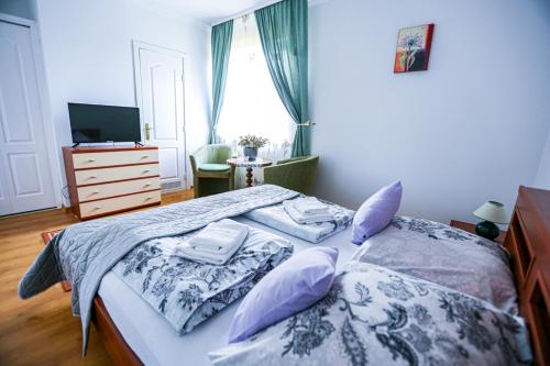 a bedroom with a bed with pillows and a television at Villa Nadmorska Łeba Centrum in Łeba