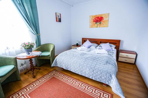 a bedroom with a bed and a table and a chair at Villa Nadmorska Łeba Centrum in Łeba