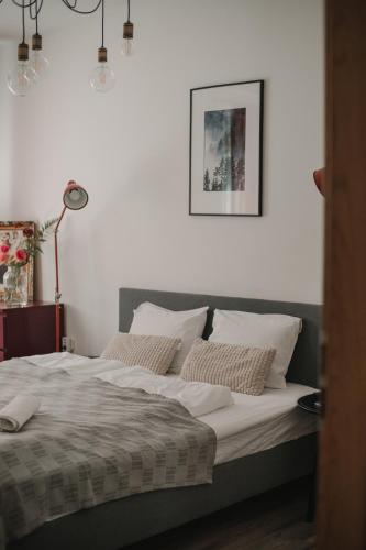 a bed with white sheets and pillows in a bedroom at Gallery Apartment 2 in Martin
