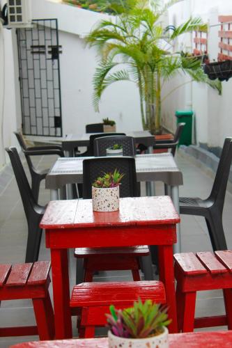 a row of tables and chairs with potted plants on them at Hotel Poblado Suite in Barranquilla