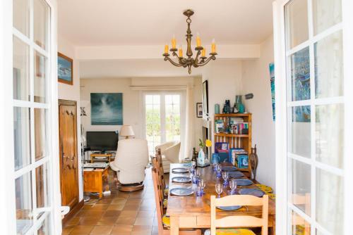 - une salle à manger avec une grande table et des assiettes dans l'établissement À 600m de la plage, maison de famille pour 9, à Penmarcʼh