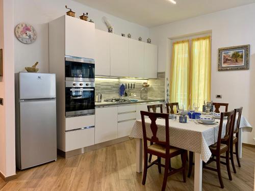 a kitchen with a table and a white refrigerator at La Casa dei Nonni in Levanto