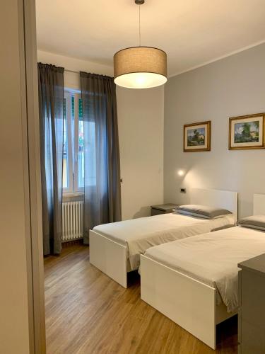 a bedroom with two beds and a chandelier at La Casa dei Nonni in Levanto