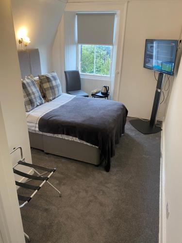 a bedroom with a bed and a television in it at Ellwyn House in Edinburgh