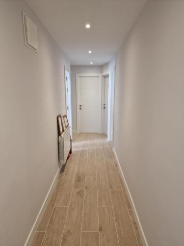 a hallway with white walls and a wooden floor at Beach Break Guesthouse in Donostia-San Sebastián