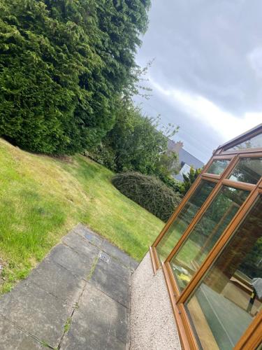 a house with a glass window next to a yard at Ellwyn House in Edinburgh