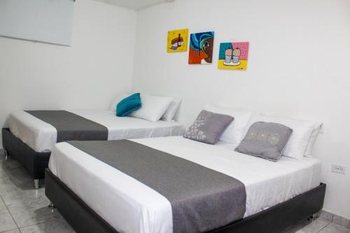 two beds sitting next to each other in a room at Hotel Poblado Suite in Barranquilla