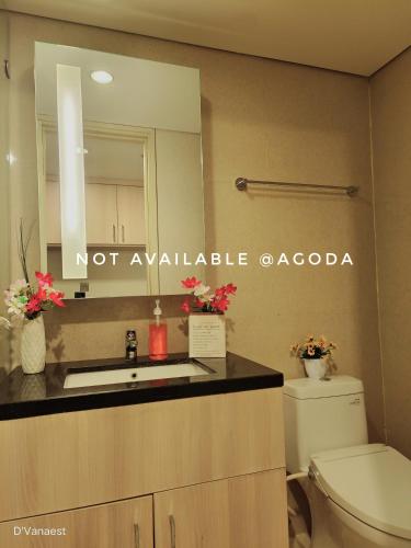 a bathroom with a toilet and a sink and a mirror at D'Vanaest in Semarang