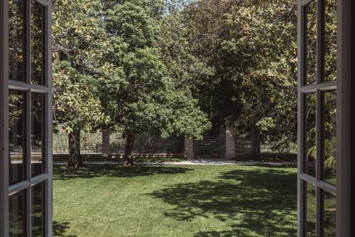 an open window looking out at a yard with trees at Château Laffitte Carcasset in Saint-Estèphe