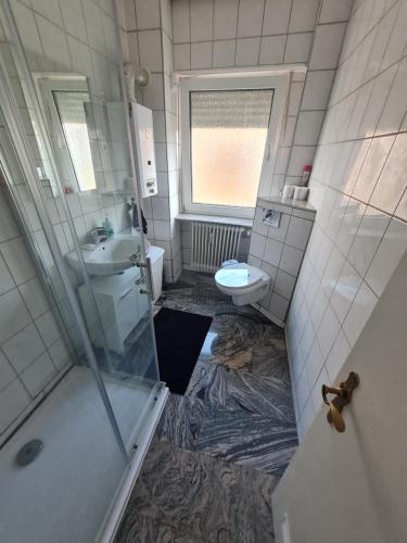 a bathroom with a shower and a sink and a toilet at Ferienwohnung Ramstein in Ramstein-Miesenbach