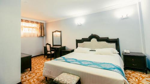 a bedroom with a bed and a desk and a mirror at Ras Amba Hotel in Addis Ababa